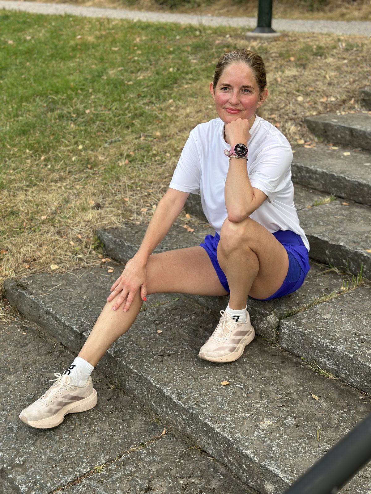 Amanda Hultin sitter på en trappa i löparkläder med sin klocka synlig vid hakan
