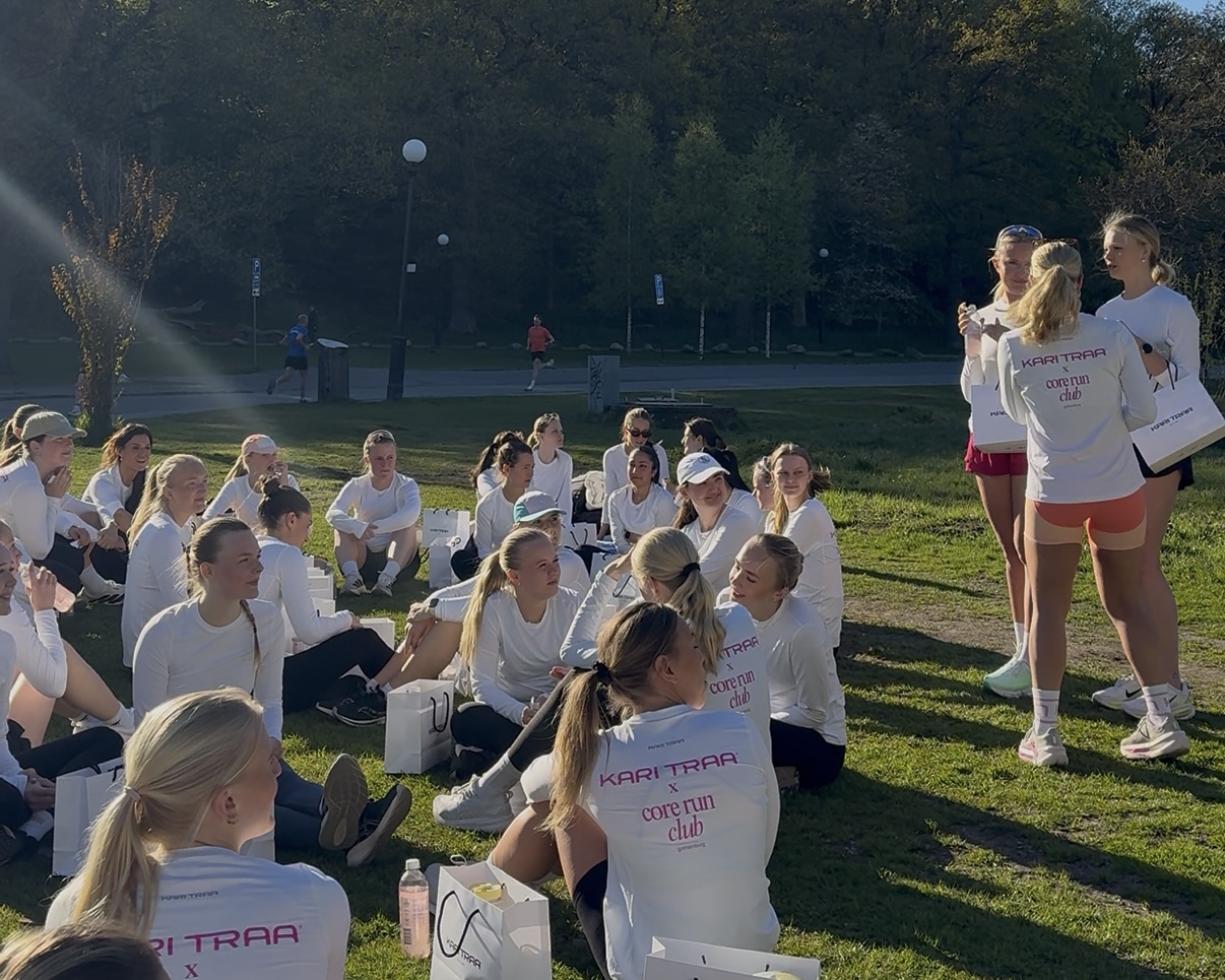 Tjejerna i Core Run Club samlade på en gräsmatta efter ett pass i samarbete med Kari Traa