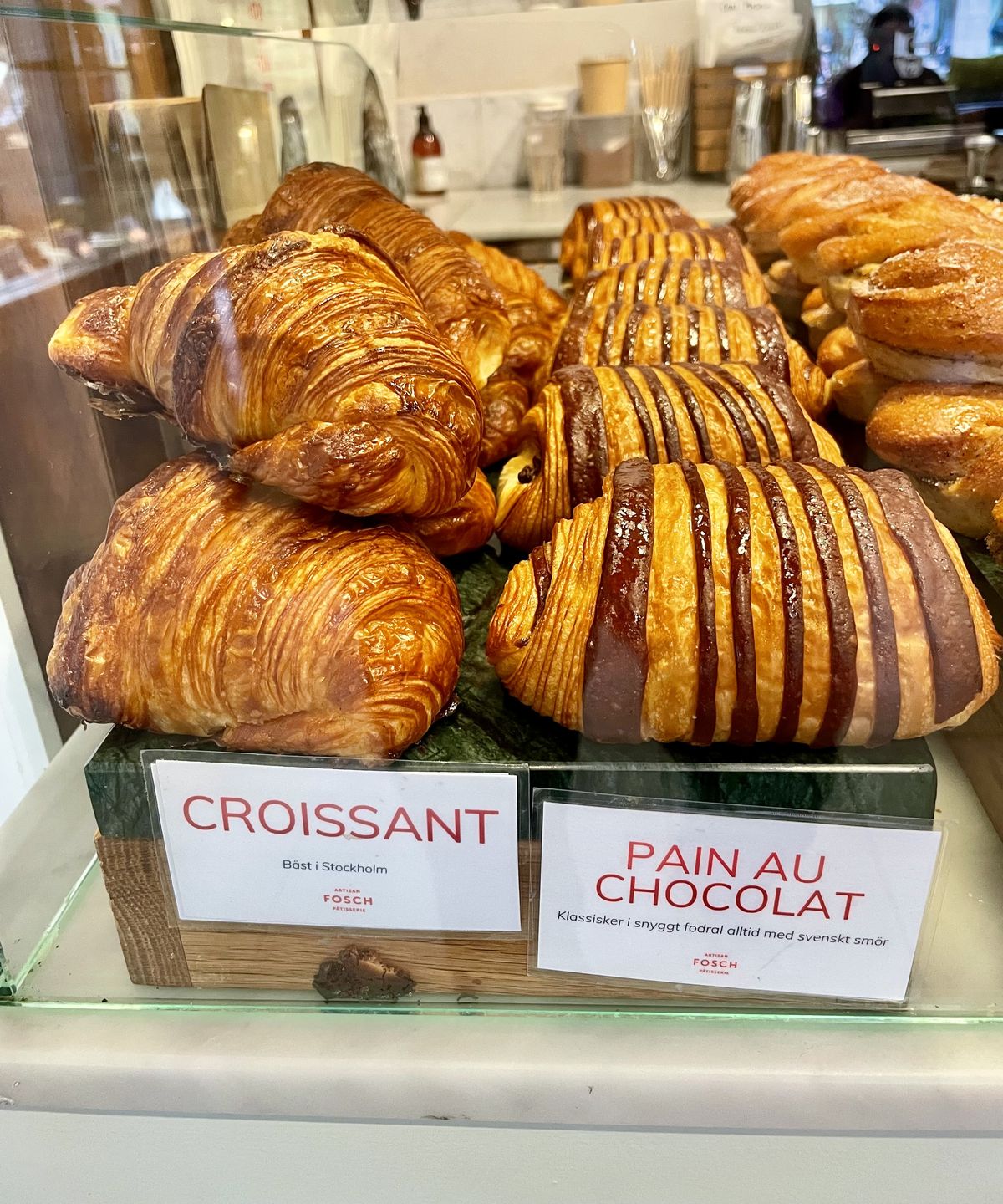 Croissanter och pain au chocolat i en glasmonter hos Fosch