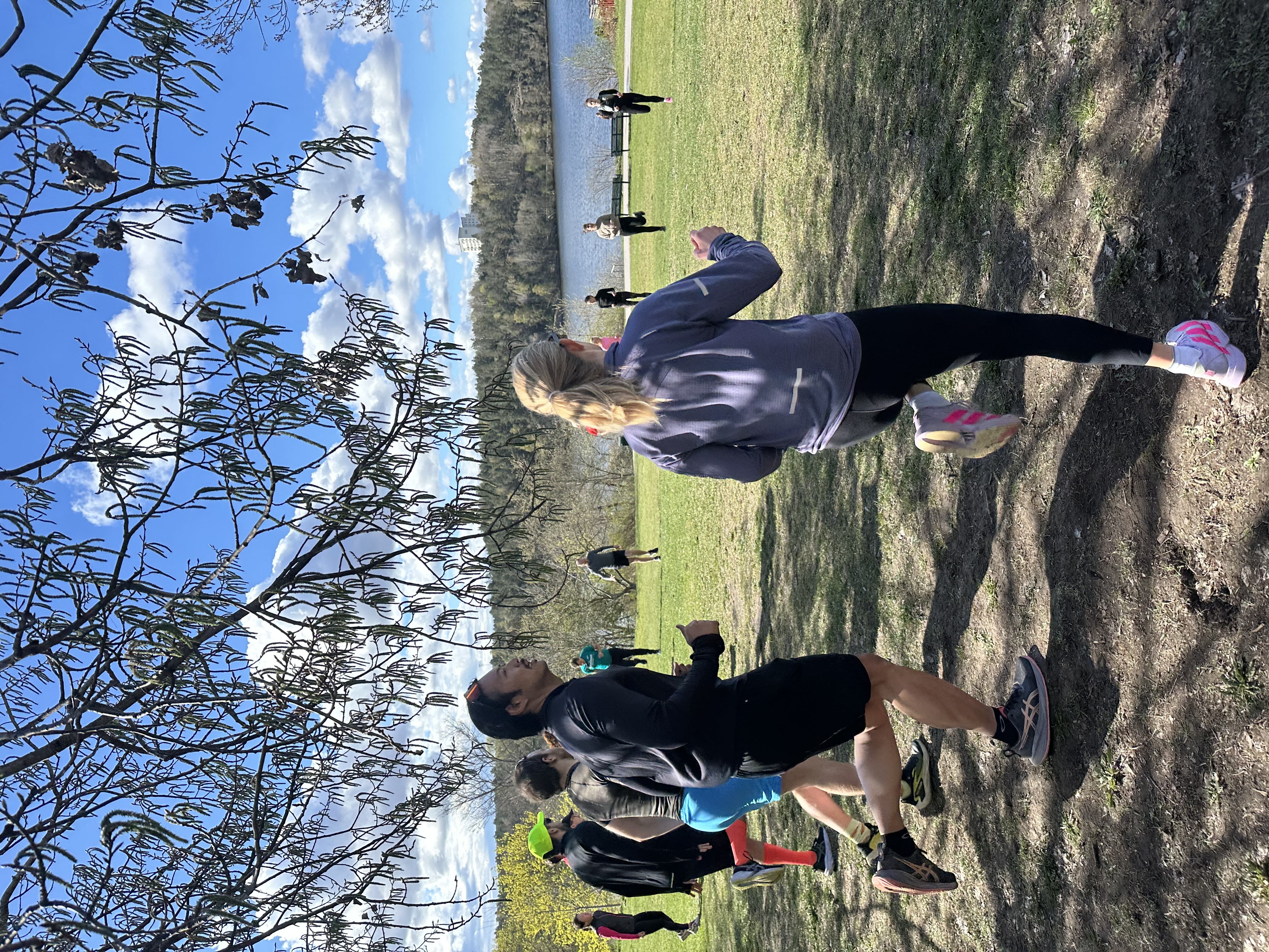 Run Collective Stockholm på pass. Gruppen springer tillsammans utomhus en solig dag