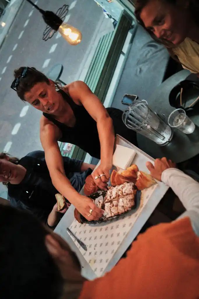 En löpare delar upp bullar och bakverk på ett fat vid ett cafébord efter passet